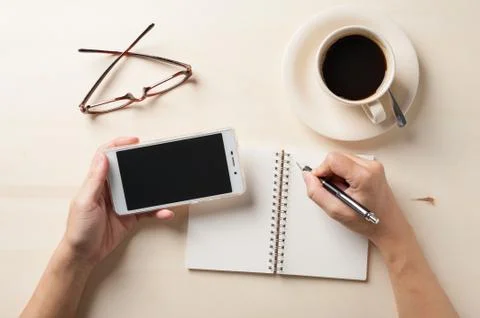 Small notebook and coffee cup Stock Photos
