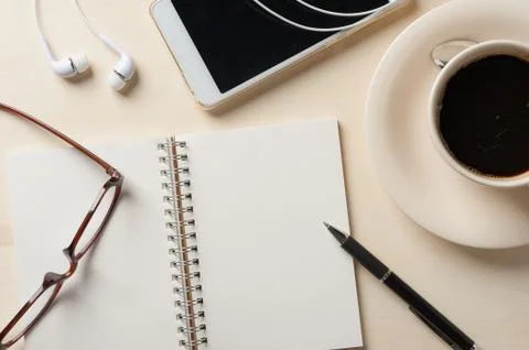 Small notebook and coffee cup Stock Photos