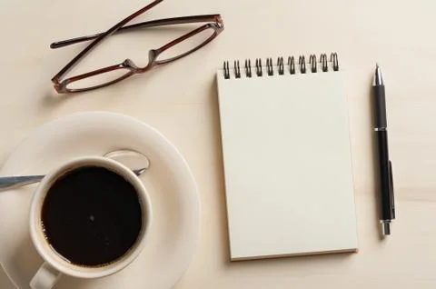 Small notebook and coffee cup Stock Photos