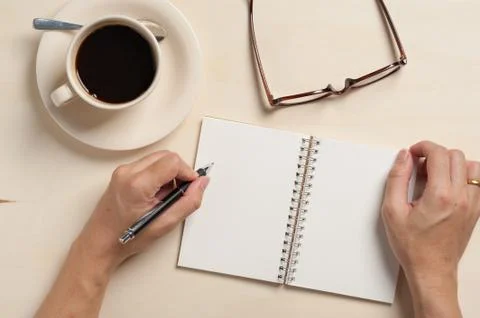 Small notebook and coffee cup Stock Photos