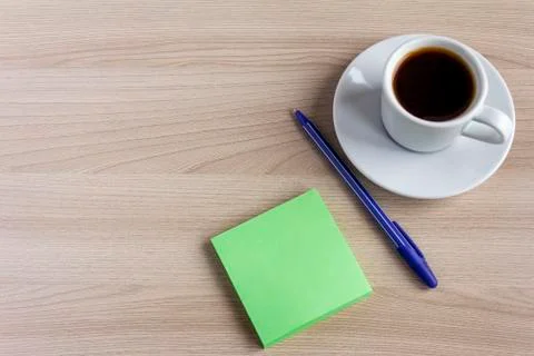 A small Notepad, a pen, and a Cup of coffee on the table.The concept of plann Stock Photos