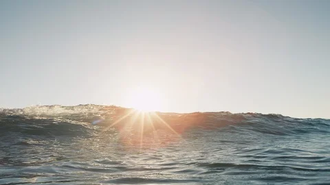 Small ocean wave breaking on camera at sunset Stock Footage 117641853