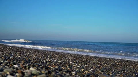 Small ocean waves rolling onto a smooth stone beach Stock Footage 333835100
