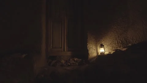A small oil light lantern lamp at wooden door in old house in Iran desert Stock Footage 260218067