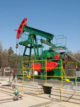 Small oil pump jack extracting crude oil Stock Photos