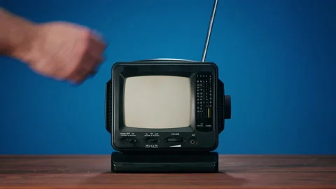 Small old television with grey interference screen on blue background. Close-up Stock Footage 168619627