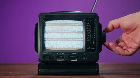 Small old television with grey interference screen on purple background. Close Stock Footage 168690049