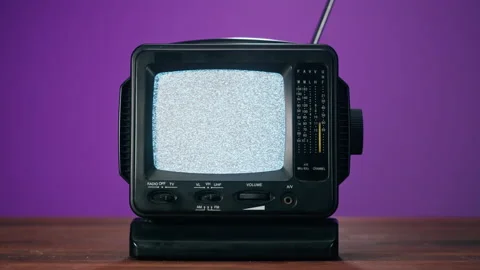 Small old television with grey interference screen on purple background. Close Vídeo Stock 169116279