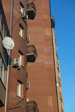A small open balcony on the facade of a brick building. Stock Photos