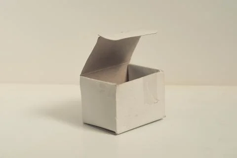 Small open square cardboard box on isolated white background, designed to fil Stock Photos