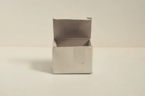 Small open square cardboard box on isolated white background, designed to fil Foto stock