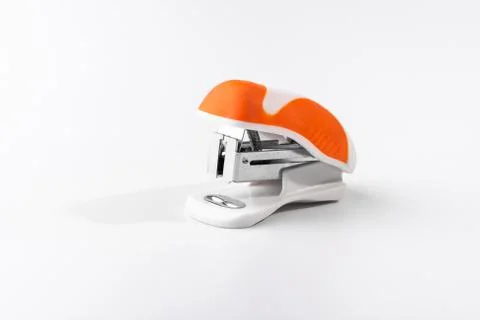 A small orange stapler isolated on a white background. Close-up. Copy space.  Stock Photos
