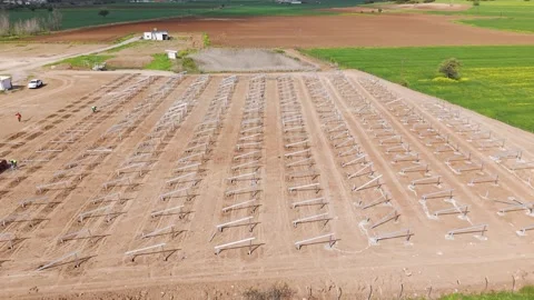 Small orbit aerial over solar mounting stands beside grass Stock-Footage 332695988