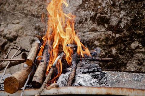 A small outdoor fire pit glows brightly with logs and kindling Stock Photos