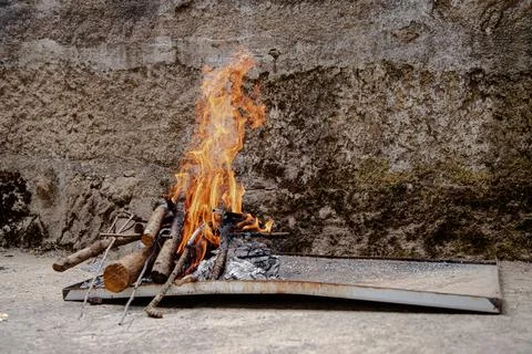 A small outdoor fire pit glows brightly with logs and kindling Stock Photos