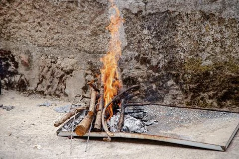 A small outdoor fire pit glows brightly with logs and kindling Stock Photos