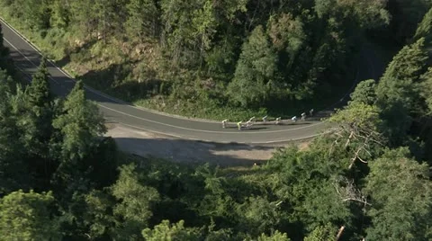 Small pack of cyclists speeding downhill Stock Footage 22204103