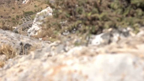 Small Pan Up from Edge of Cliff to Road Below Stock Footage 78246917