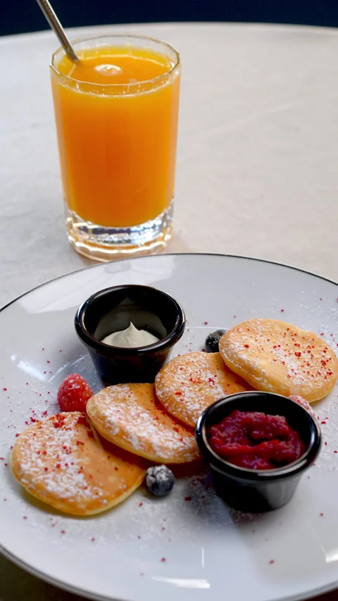 Small pancakes dusted with powdered sugar, accompanied by fresh berries, jam Video stock 312363437