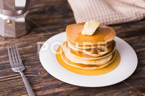 Small pancakes with maple syrup and butter on wooden table. Breakfast concept. Stock Photos