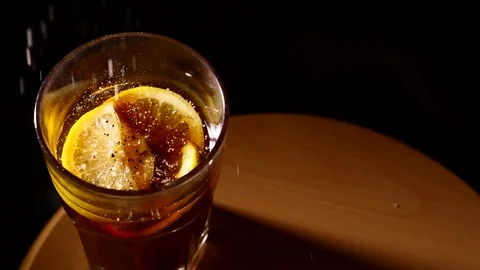 Small particles falling into glass of cocktail slowmo Stock Footage 84073985
