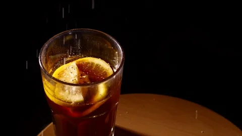 Small particles falling into glass of cocktail slowmo Stock Footage 84074109