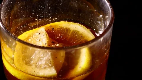 Small particles falling into glass of cocktail slowmo Stock Footage 84074150