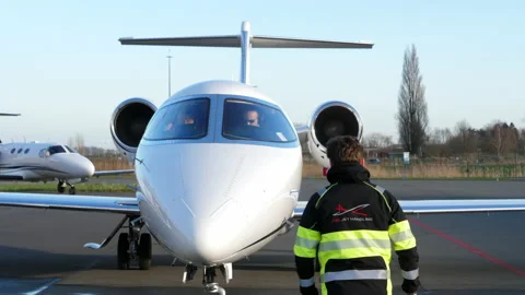 Small passenger aircraft Learjet 45 arriving, pilots in the cockpit and Video stock 172534896