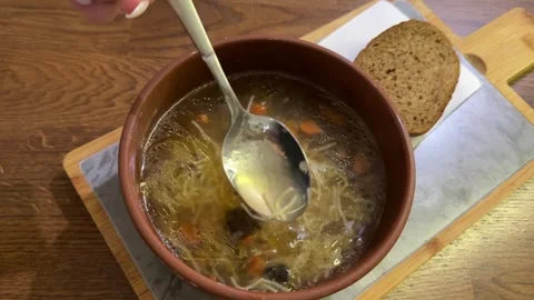 Small pasta noodles Serving of the hot vegetable soup with chicken meat in clay Stock Footage 327293433