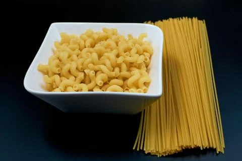 Small pasta in the shape of a spring in a white plate Spaghetti pasta on a da Stock Photos