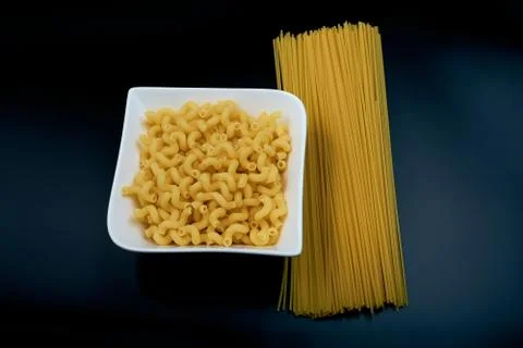 Small pasta in the shape of a spring in a white plate Spaghetti pasta on a da Stock Photos
