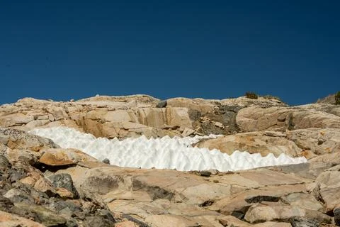 Small Patch Of Melting Snow Below A Deep Blue Sky Stock Photos