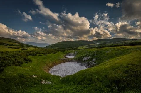 Small patch of snow in the summer in the middle of grassy meadow in rax plateau Foto stock