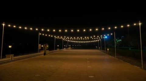 Small pathway decorated with string lights Stock Photos