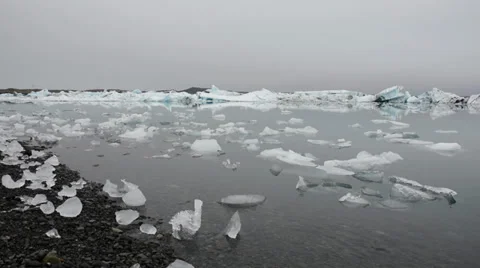 Small peaces of ice being thrown at the pebble beach at Glacier lagoon, Iceland Stock Footage 33778508