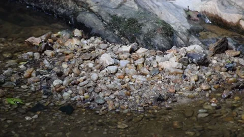SMALL PEBBLES ON THE BED OF A STREAM Stock Footage 132455210