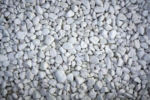 Small pebbles painted in white, texture. Stock Photos