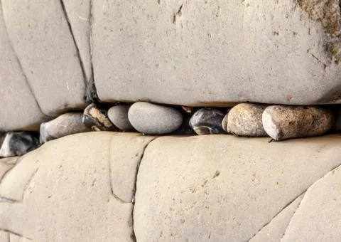 Small pebbles stuck in between larger rocks Stock Photos