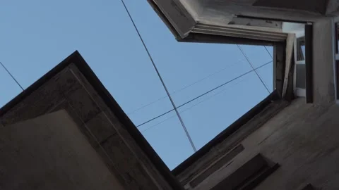 A small piece of blue sky with a web of wires over a well in the courtyard. Stock Footage 157287196