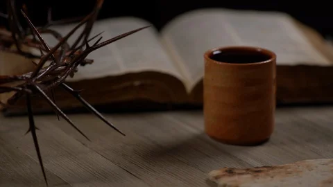 Small Pieces of Bread being placed on table with Cup, Crown of Thorns and Bible Video stock 128587210