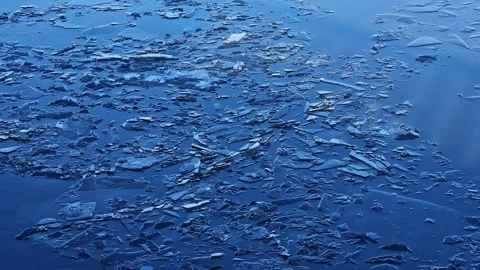 Small pieces of broken ice on smooth surface of blue water Stock Footage 346376125