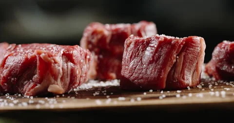 Small pieces of fresh beef on preparation table on professional kitchen. Juicy Vídeo Stock 144563825