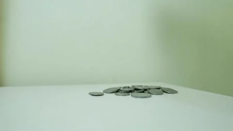 Small pile of coins on a white surface against a plain background Stock Footage 317737404