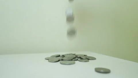 Small pile of coins on a white surface against a plain background Stock Footage 317737408