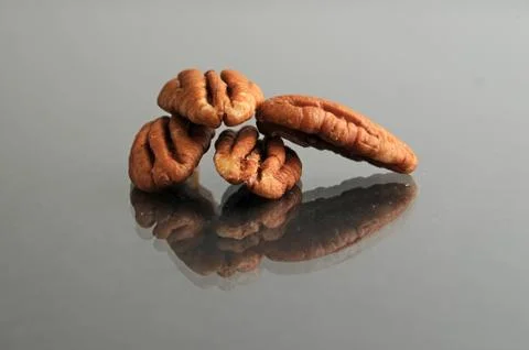 A small pile of pecans on a black surface Stock Photos