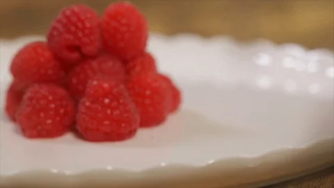 Small Pile of Raspberries lying on a Rotating Plate Closeup Stock Footage 99163020