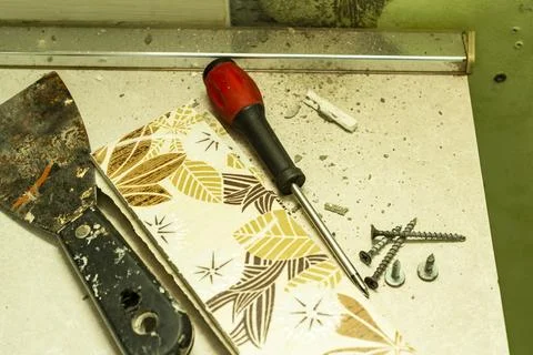 A small pile of self-tapping screws and a screwdriver, as well as several c.. 스톡 사진