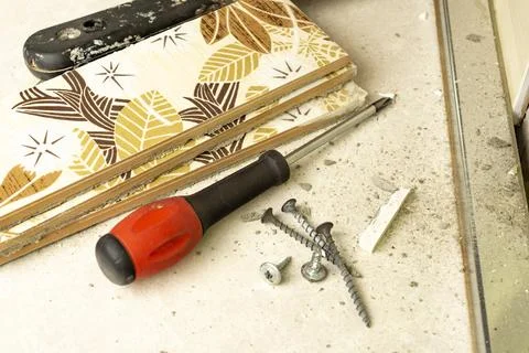 A small pile of self-tapping screws and a screwdriver, as well as several c.. Stock Photos