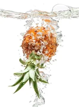 Small pineapple falling in water on white Stock Photos