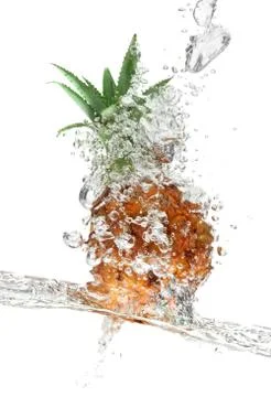 Small pineapple falling in water on white Stock Photos